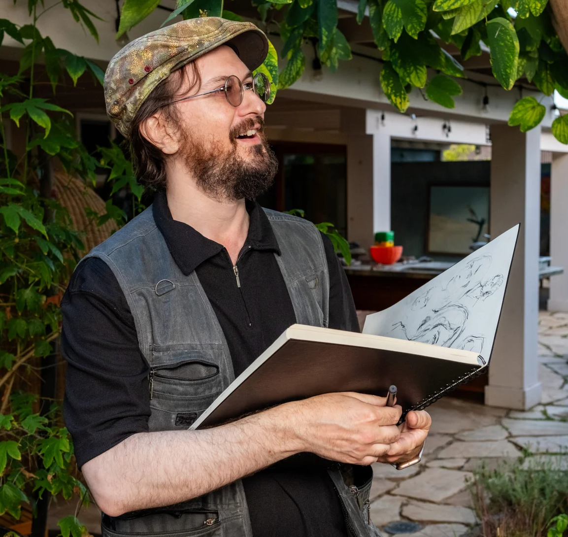 Oleg Tsank holding sketch book in hand.