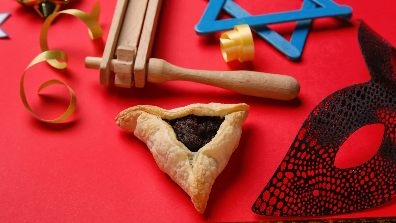 a photo of a homentaschen, a mask, a noise maker, and a star of david, advertisement for a purim party.