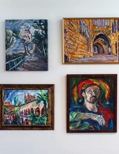 Four Yiddish-themed paintings by Oleg Tsank displayed on the wall at Yiddishland California.